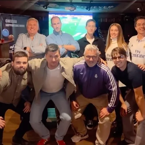Socios con la camiseta del Real Madrid ante las pantallas
